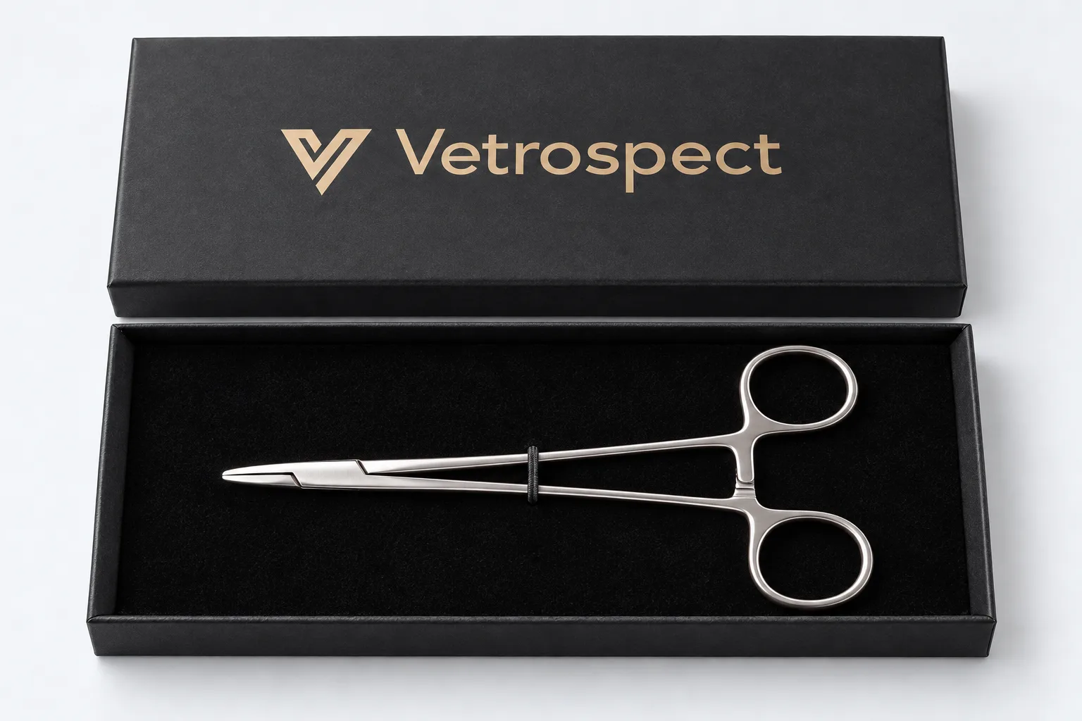 Vetrospect needle holder resting in its open black presentation box, with the Vetrospect name in gold on the lid
